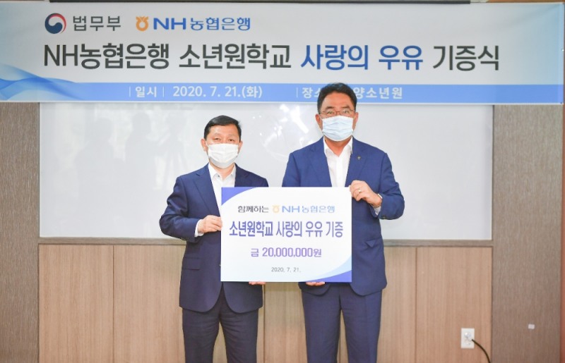 지준섭 NH농협은행 농업·공공금융부문 부행장(오른쪽)과 강호성 법무부 범죄예방정책국 국장(왼쪽)이 사랑의 우유 기증식을 갖고 기념촬영을 하고 있다. /사진=NH농협은행