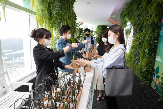 24일 롯데월드타워 서울스카이를 찾은 관람객에게 스투키 화분을 선물하는 모습. / 사진 = 롯데월드
