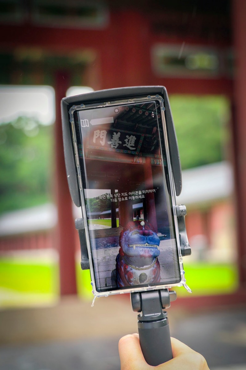 SK텔레콤 홍보모델들이 창덕궁 인정전 앞에서 '창덕 ARirang' 서비스를 체험하는 모습/사진=SK텔레콤