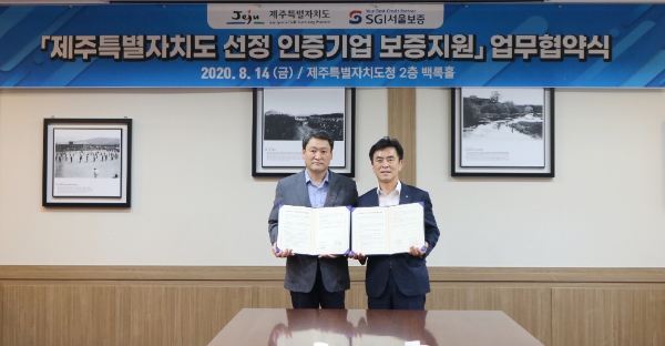 제주도청에서 지난 14일 남상일 SGI서울보증 전략기획본부장(오른쪽)과 손영준 제주도 일자리경제통상국장이 ‘제주도 선정 인증기업 보증지원 업무협약’을 체결하고 있다. / 사진 = SGI서울보증