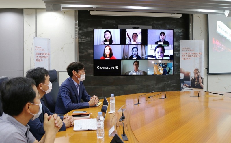 ▲ 엄격한 심사 과정을 거쳐 선발된 ‘고객 컨설턴트’ 8명〈스크린 화면〉과 온택트(Ontact) 발대식을 갖고 있는 오렌지라이프 직원들./사진제공=오렌지라이프