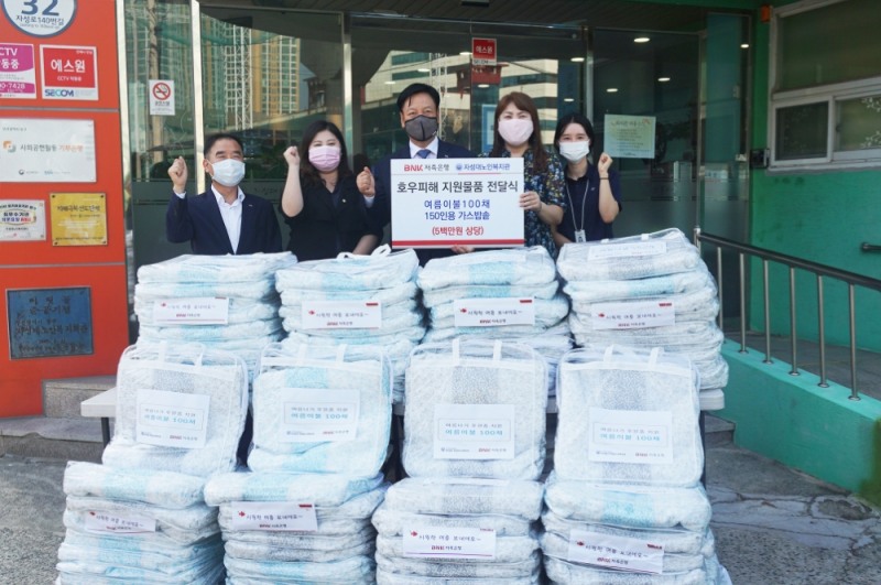(오른쪽에서 두번째부터) 자성대 노인복지관 이은숙 관장, 성명환 BNK저축은행 대표이사, 김선경 부산광역시 동구의회 의원이 구호물품 전달 후 기념촬영을 하고 있다./사진=BNK저축은행