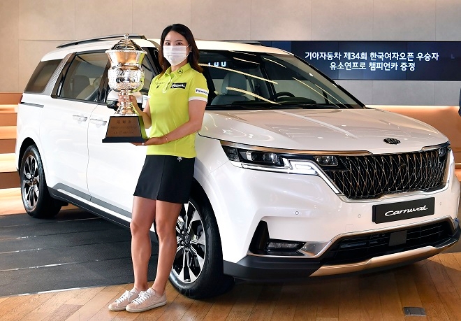 유소연 선수가 부상으로 받은 4세대 카니발 앞에서 기념촬영을 하고 있다. 사진=기아차.