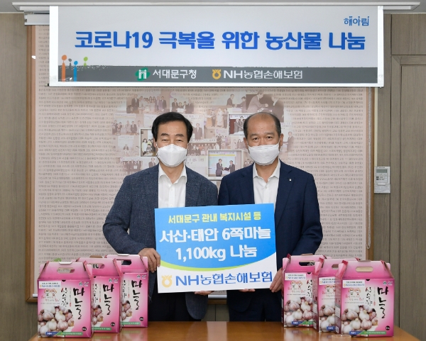 NH농협손해보험은 지난 27일 서울 서대문구청을 찾아 코로나19 극복을 위한 농산물 나눔 행사를 실시했다. 서산·태안 마늘 1100kg을 전달 후 최창수 대표이사(오른쪽)와 문석진 서대문구청장(왼쪽)이 기념사진 촬영을 하고 있다. / 사진 = NH농협손해보험