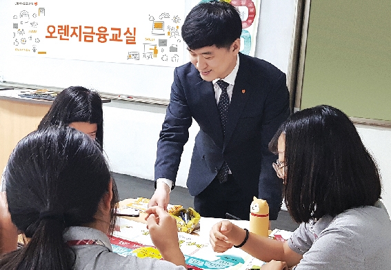 ▲ 서울 한 중학교에서 진행된 오렌지금융교실에서 오렌지라이프 FC가 진로설계 보드게임을 활용해 학생들에게 금융 교육을 진행하고있다. 사진 = 오렌지라이프
