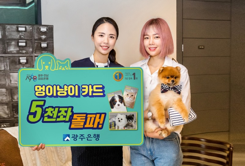 ▲광주은행 '멍이냥이카드'를 이용중이며, 광주은행 본점 인근에서 커피샵 <아카이브>를 운영 중인 배우 한주영(사진 오른쪽, 영화 '상류사회' 민현아 역)이 반려견 '쿠모'와 함께 '멍이냥이카드' 5천좌 돌파 축하 기념 촬영을 하고 있다./ 사진제공 = 광주은행
