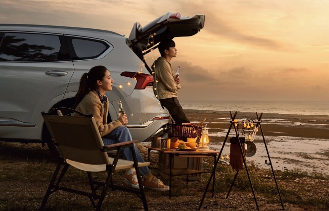 현대차 모델이 싼타페 앞에서 캠핑을 즐기는 모습을 시연하고 있다.