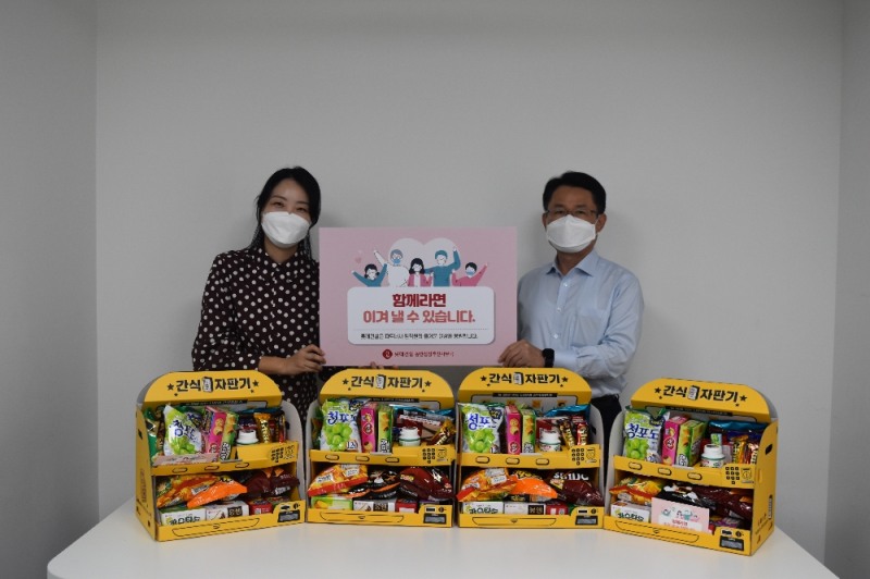 ▲롯데건설이 파트너사에 제공한 롯데제과 간식 자판기 (롯데건설 외주구매본부장 석균성 전무(우측))/ 사진제공 = 롯데건설