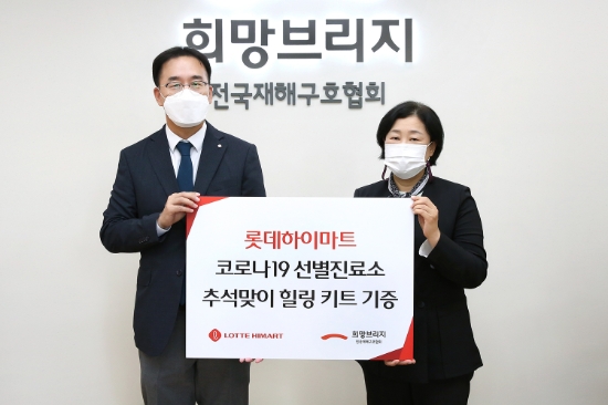 윤용오 롯데하이마트 생활부문장(왼쪽)이 서울 마포구 희망브리지 전국재해구호협회에서 김정희 전국재해구호협회 사무총장과 기념촬영을 하고 있다. / 사진 = 롯데하이마트