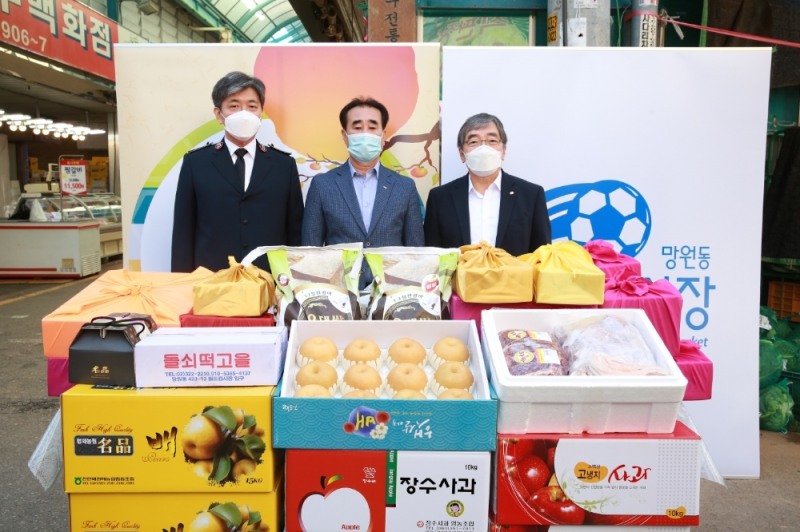 윤석헌 금융감독원장(오른쪽)이 망원월드컵시장에 방문해 생필품 및 전통시장상품권을 구매한 후 사회복지단체에 전달했다. /사진=금감원