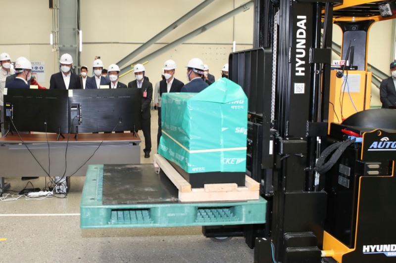 KT와 현대건설기계 관계자들이 현장에 적용된 무인지게차 시연을 지켜보고 있다./사진=KT