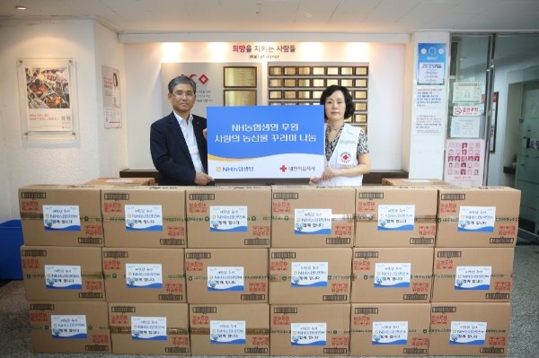 전용범 NH농협생명 경영기획부문 부사장(왼쪽)과 박명숙 대한적십자사 중앙봉사관장(오른쪽)이 추석맞이 농산물 꾸러미 나눔을 기념해 포즈를 취하고 있다. / 사진 = NH농협생명