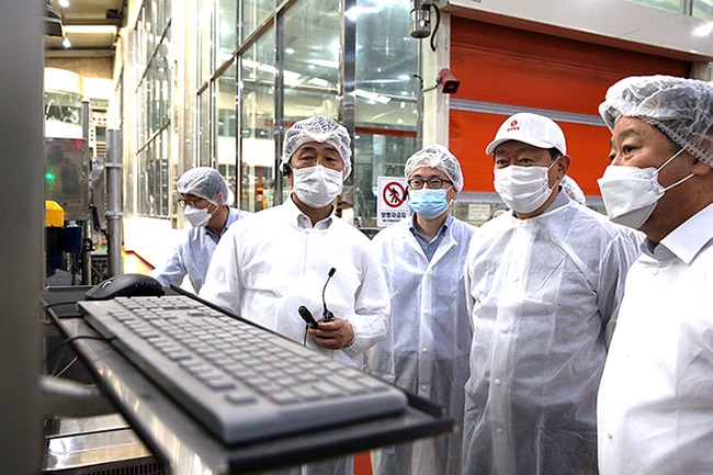 ▲ 지난 6월 신동빈 회장이 경기 안성시에 위치한 롯데칠성음료 스마트팩토리를 방문해 코딩 검사기를 바라보고 있다. 사진 = 롯데지주