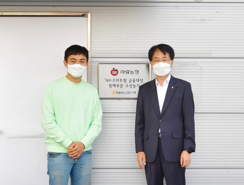 손병환 NH농협은행장(오른쪽)과 허정수 하랑농장 대표(왼쪽)가 지난 12일 전북 김제시에 위치한 ‘하랑농장’에서 ‘NH 스마트팜 금융대상’ 현판식을 진행했다. /사진=NH농협은행