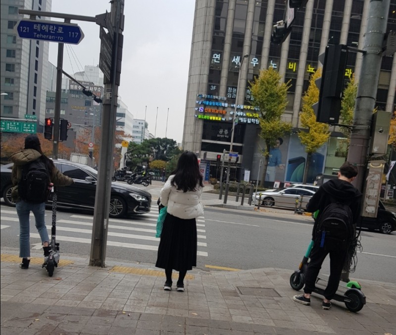 횡단보도 신호 대기 중인 보행자와 전동킥보드 이용자들의 모습/사진=한국금융신문 
