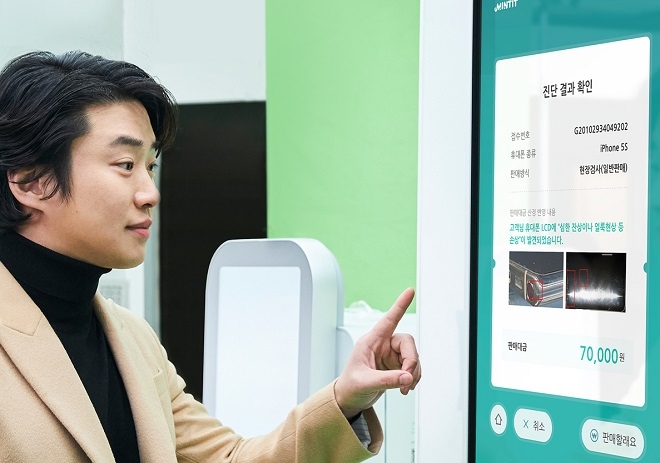 민팃ATM 홍보모델 안재홍이 이미지 기능이 추가된 민팃ATM미니를 시연하고 있다. 사진=SK네트웍스.