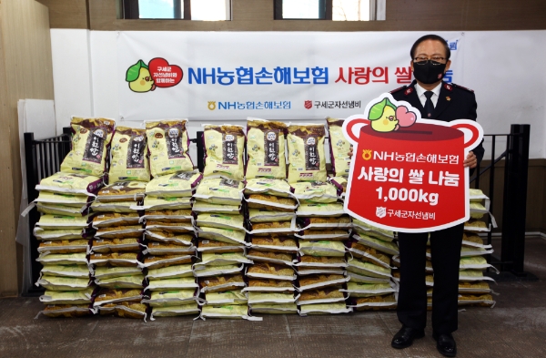 NH농협손해보험은 22일 서울 구세군 자선냄비에 우리 농산물을 전달하는 ‘사랑의 쌀 나눔’ 활동을 실시했다. 구세군 자선냄비 곽창희 사무총장이 전달 된 물품 앞에서 기념 촬영을 하고 있다. / 사진 = NH농협손해보험