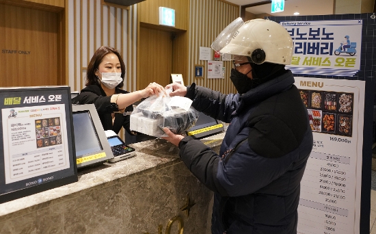 울 강남구 삼성동에 위치한 씨푸드 뷔페 보노보노 삼성점에서 직원이 배달 라이더(배달원)에게 음식을 전달하고 있다. / 사진 = 신세계푸드