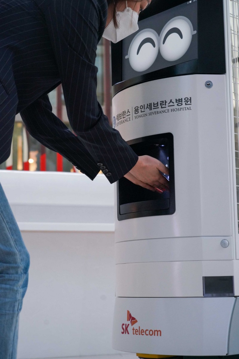 ‘Keemi’가 손소독제를 내원객에게 제공하는 모습. 사진=SK텔레콤