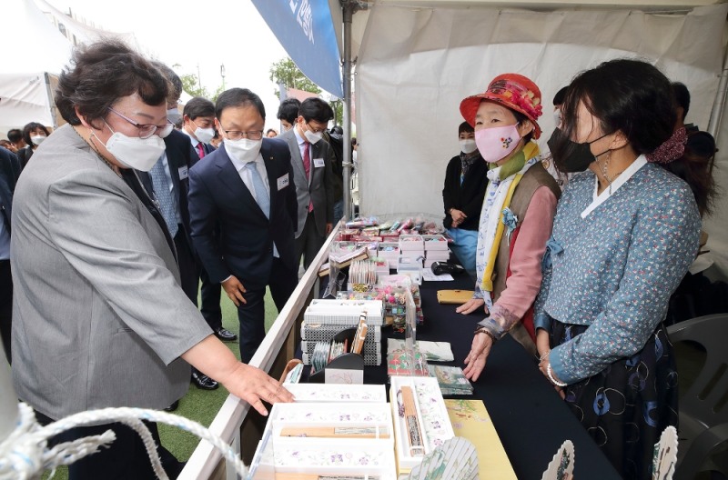 KT 구현모 대표(왼쪽 두 번째)가 나눠정(情) 나눔장터에서 인사동 전통물품에 대한 설명을 듣고 있다. 사진=KT