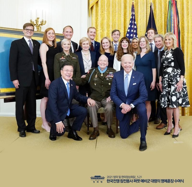 2021년 5월 22일 백악관 이스트룸에서 열린 한국전쟁 명예 훈장 수여식에서 문재인 대통령, 조 바이든 미국 대통령, 랠프 퍼켓 주니어 예비역 대령 가족과 기념촬영을 하고 있다. / 사진=청와대