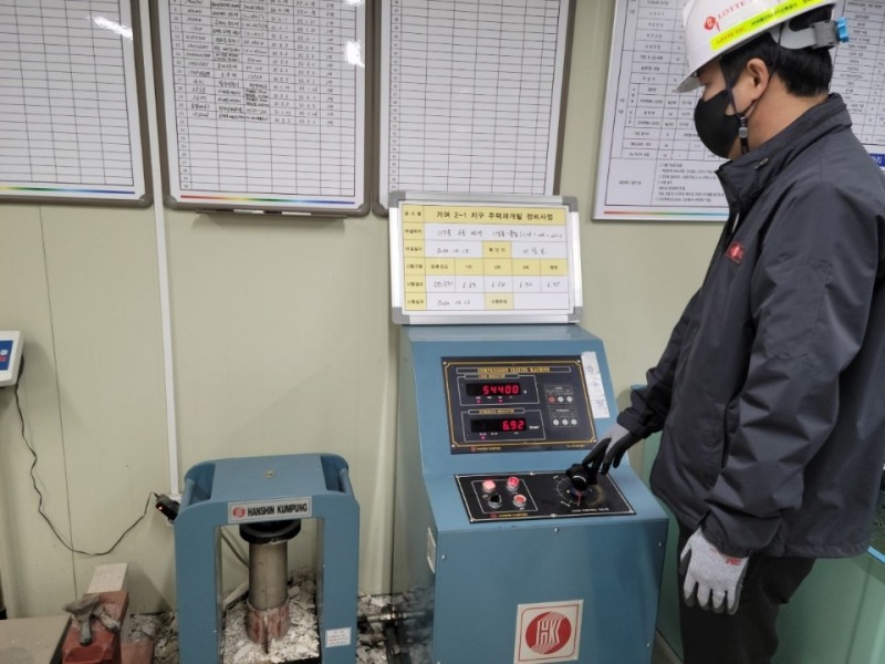 롯데건설이 롯데케미칼, 동남기업과 함께 개발한 화학 혼화제를 현장에 적용해 압축 강도를 테스트하는 모습. / 사진=롯데건설