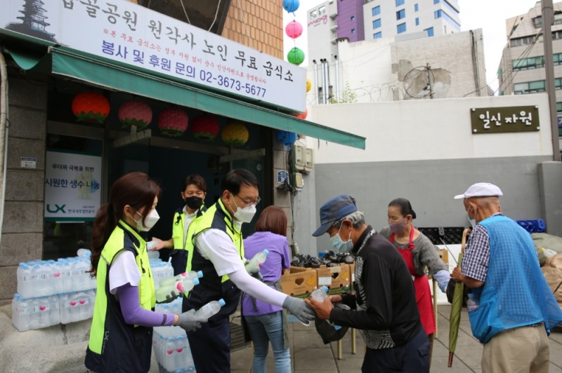 이승택 LX한국국토정보공사 서울지역본부 직무대행(왼쪽에서 세 번째) 등 임직원들이 서울 탑골공원 원각사 무료급식소에서 이용자들에게 얼음물을 나눠주고 있다. /사진제공=LX공사