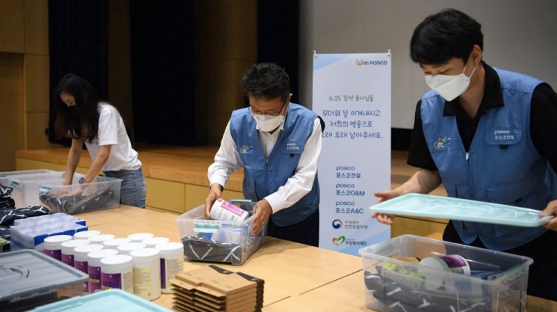 한성희 포스코건설 사장(사진 가운데)이 임직원들과 함께 6·25 참전 유공자를 위한 폭염 피해방지 키트를 제작하고 있다. / 사진=포스코건설