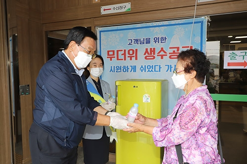 ▲ 정해명 홍성농협조합장(왼쪽)은 무더위 극복을 위한 폭염냉장고를 본점 객장에 설치하고 농협을 방문한 지역주민에게 시원한 얼음물을 전달하고 있다.