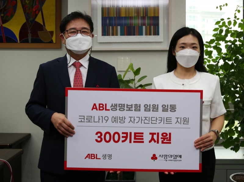 이상윤 ABL생명 인적자원실장(왼쪽)이 방성진 사랑의열매 사회공헌팀장에게 코로나19 예방 키트 300개를 전달하고 기념촬영을 하고 있다./사진=ABL생명