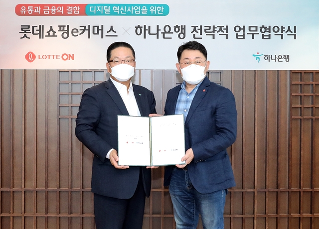 이호성 하나은행 중앙영업그룹 총괄부행장(왼쪽)과 나영호 롯데쇼핑 e커머스사업부 대표가 지난 19일 서울 중구 을지로 하나은행 본점에서 디지털사업 공동 추진을 위한 업무협약을 체결한 뒤 협약서를 들어 보이고 있다./사진=하나은행
