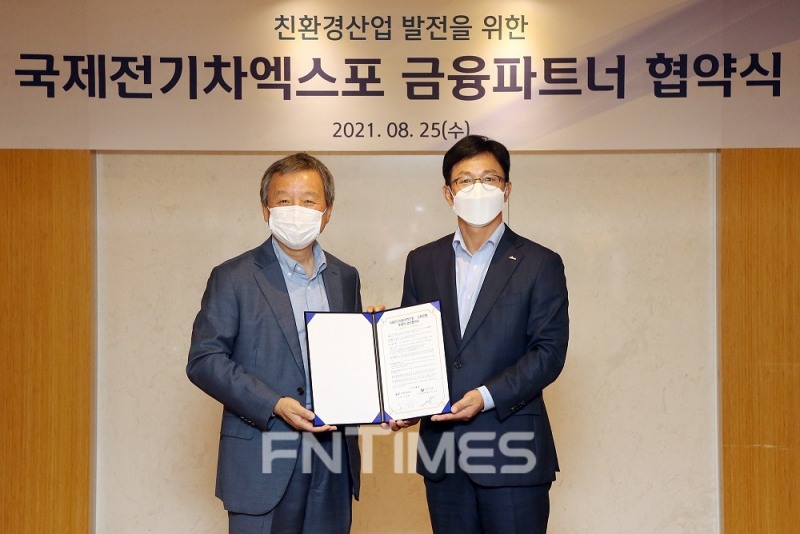 정지호 신한은행 부행장(오른쪽)과 김대환 국제전기자동차엑스포 이사장이 25일 서울시 중구에 있는 대한상공회의소에서 친환경 산업 발전을 위한 업무협약을 체결한 뒤 기념촬영하고 있다./사진=신한은행