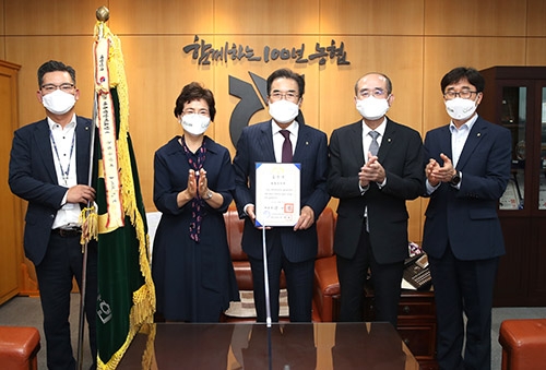 ▲ 대통령 표창 패를 들고 있는 이성희 회장(가운데).