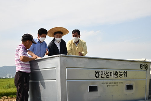 ▲ 사진은 오른쪽에서 두 번째 농협경기지역본부 정용왕 본부장이 수확한 벼를 보고 있다 .