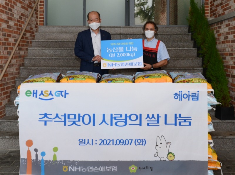 NH농협손해보험 최창수 대표이사가 안나의 집 김하종 신부(사진 오른쪽)와 기념 촬영을 하고 있다./사진=농협손해보험