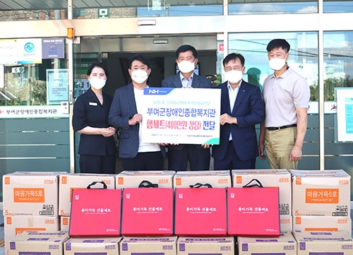 ▲ 이기범 (사)우리농업지키기운동 충남본부장(왼쪽 두번째)와 이승훈 NH농협은행 부여군지부장(왼쪽 네 번째)은 박종화 부여군장애인종합복지관장(가운데)에게 400만원상당의 우리 농축산물를 전달했다.