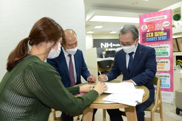 김명수 경기 의정부농협 조합장(사진 오른쪽)이 NH농협손해보험 최창수 대표이사로부터 상품 설명을 들으며 1호로 가입하고 있다./사진제공= NH농협손해보험