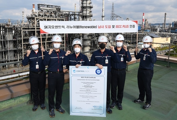 SK 울산컴플랙스에서 직원들이 ISCC PLUS 인증서 확대본을 들고 기념촬영을 하고 있다. 제공=SK이노베이션.