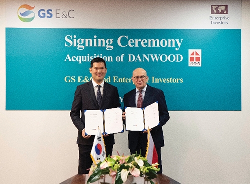 ▲ 허윤홍 GS건설 신사업부문 대표 사장이 지난해 폴란드 단우드 본사에서 야첵 스비츠키 단우드 사장과 함께 인수를 마무리하는 서류에 서명 후 기념촬영 하고 있다.