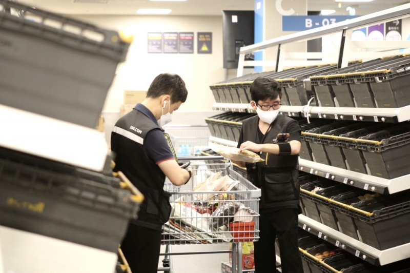 작업자가 DAS에 도착한 상품을 배송 바스켓으로 옮기는 모습./ 사진제공 = SSG닷컴