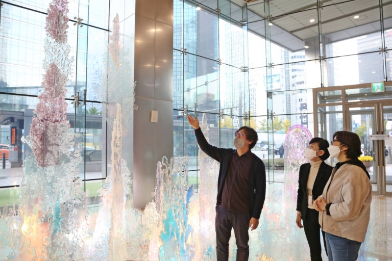 신한카드 본사 사옥 로비에 전시 중인 설치미술 작품 ‘숨의 숲’에 대하여 ‘홍범’ 작가가 설명하고 있다. /사진제공=신한카드