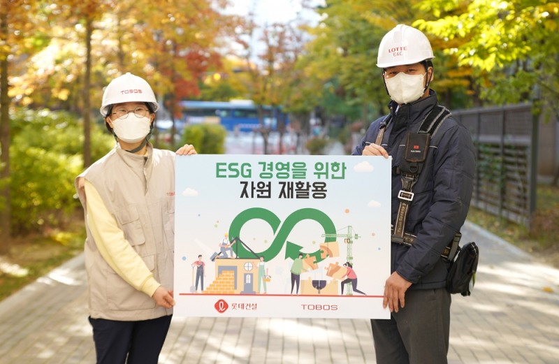 토보스 김소연 대표(왼쪽)와 롯데건설 임직원이 ‘ESG 경영을 위한 자원 재활용’ 홍보 보드판을 들고 있다. / 사진제공=롯데건설