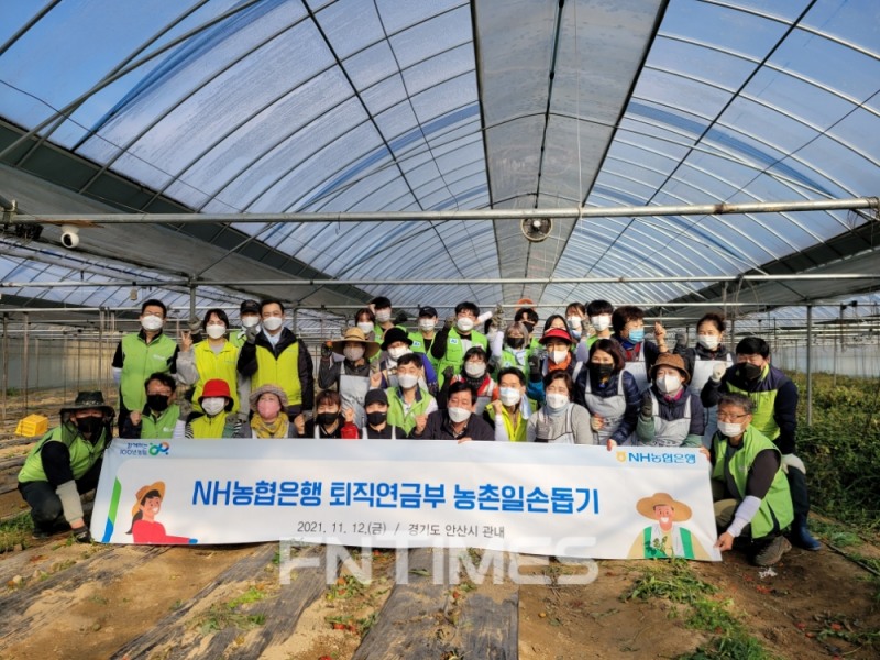 NH농협은행 퇴직연금부 민병도 부장과 직원들이 지난 12일 경기도 안산시 관내 농가에서 일손을 도운 뒤 기념촬영하고 있다./사진=NH농협은행