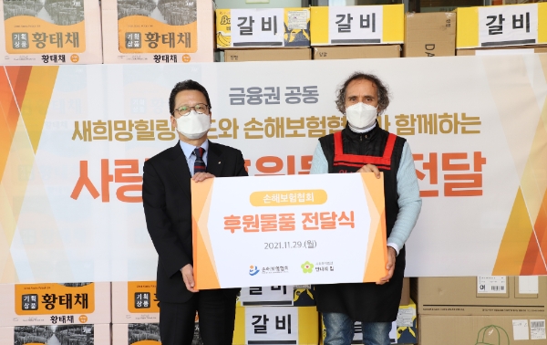 정지원 손해보험협회 회장(사진 왼쪽)이 김하종 안나의 집 신부에게 후원물품을 전달하고 있다./사진 제공= 손해보험협회