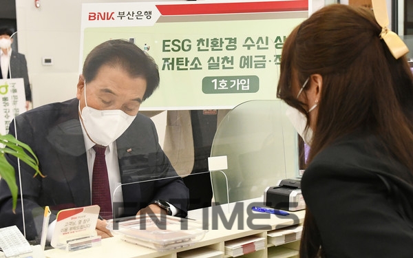 김지완 BNK금융그룹 회장이 지난 5월 오전 본점 영업부를 방문해 ‘저탄소 실천 적금’을 1호로 가입하고 있는 모습./사진=BNK부산은행