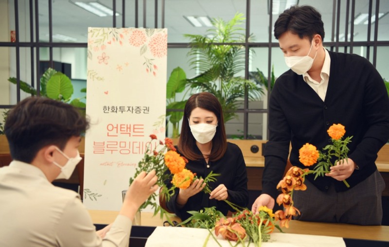 한화투자증권 직원들이 꽃으로 희망을 나누는 '블루밍 데이'에 참여하고 있다. / 사진제공=한화투자증권
