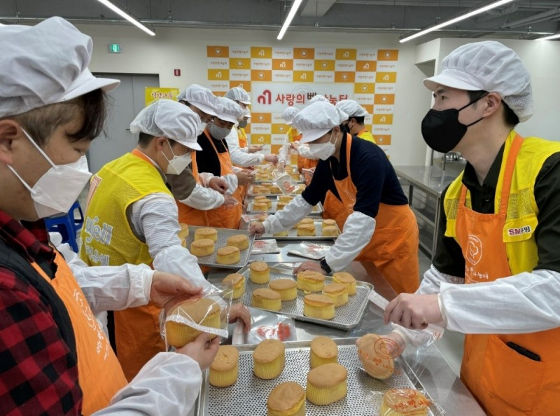SM우방 임직원들이 대구시 서구에 마련된 제빵소에서 제빵봉사를 하면서 행사관계자들과 담소를 나누고 있다. /사진제공=SM우방