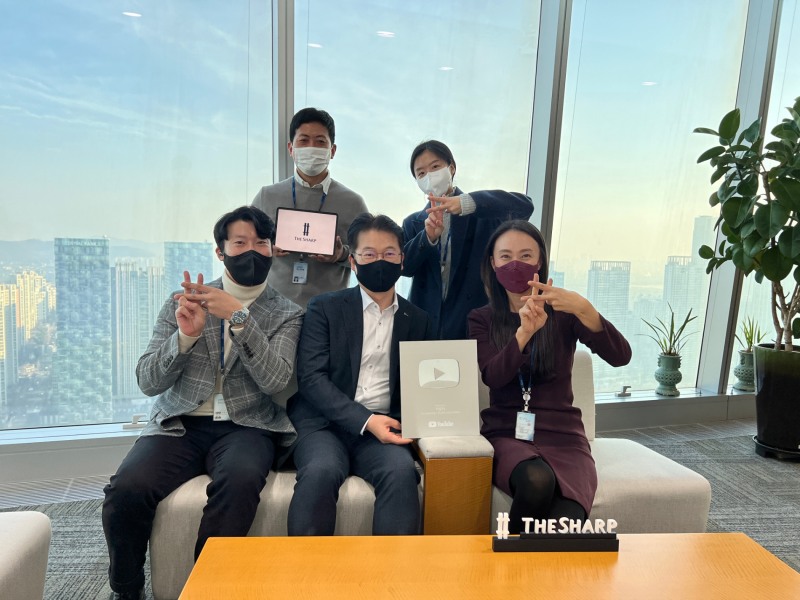 포스코건설 건축사업본부 직원들이 '더샵TV'의 구독자 10만명 돌파를 축하하고 있다. / 사진제공=포스코건설