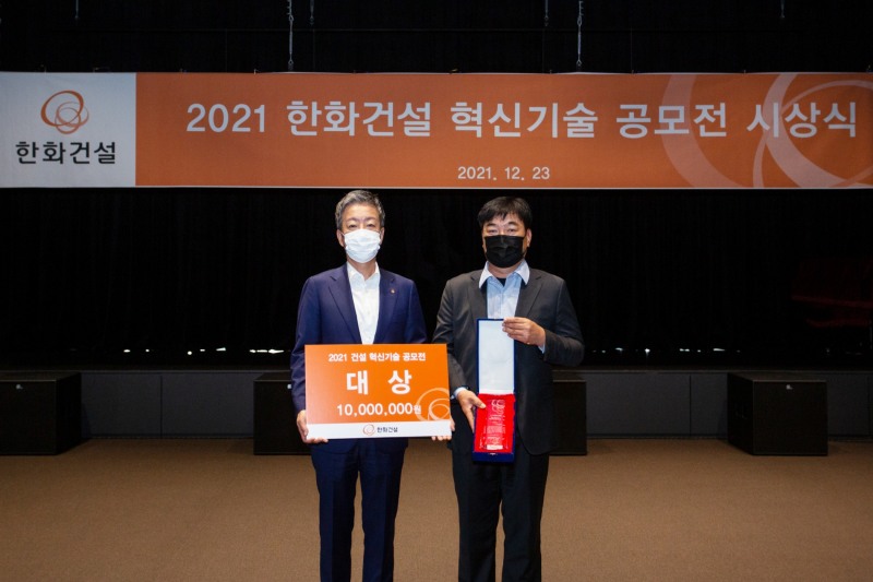 한화건설이 23일 진행한 ‘2021 한화건설 혁신기술 공모전’ 시상식에서 대상을 수상한 유석토건(주)의 김명원 대표(우측)와 한화건설 윤용상 건축사업본부장(좌측)이 기념촬영을 하고 있다. / 사진제공=한화건설