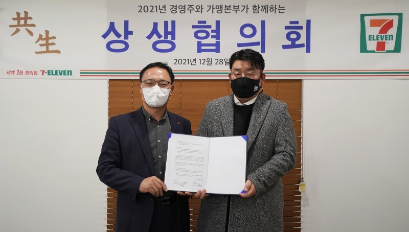 (왼쪽부터) 최경호 세븐일레븐 대표와 계상혁 세븐일레븐 경영주협의회장이‘2022 가맹점 상생협약’ 체결하고 기념사진을 촬영하고 있다./사진제공=세븐일레븐